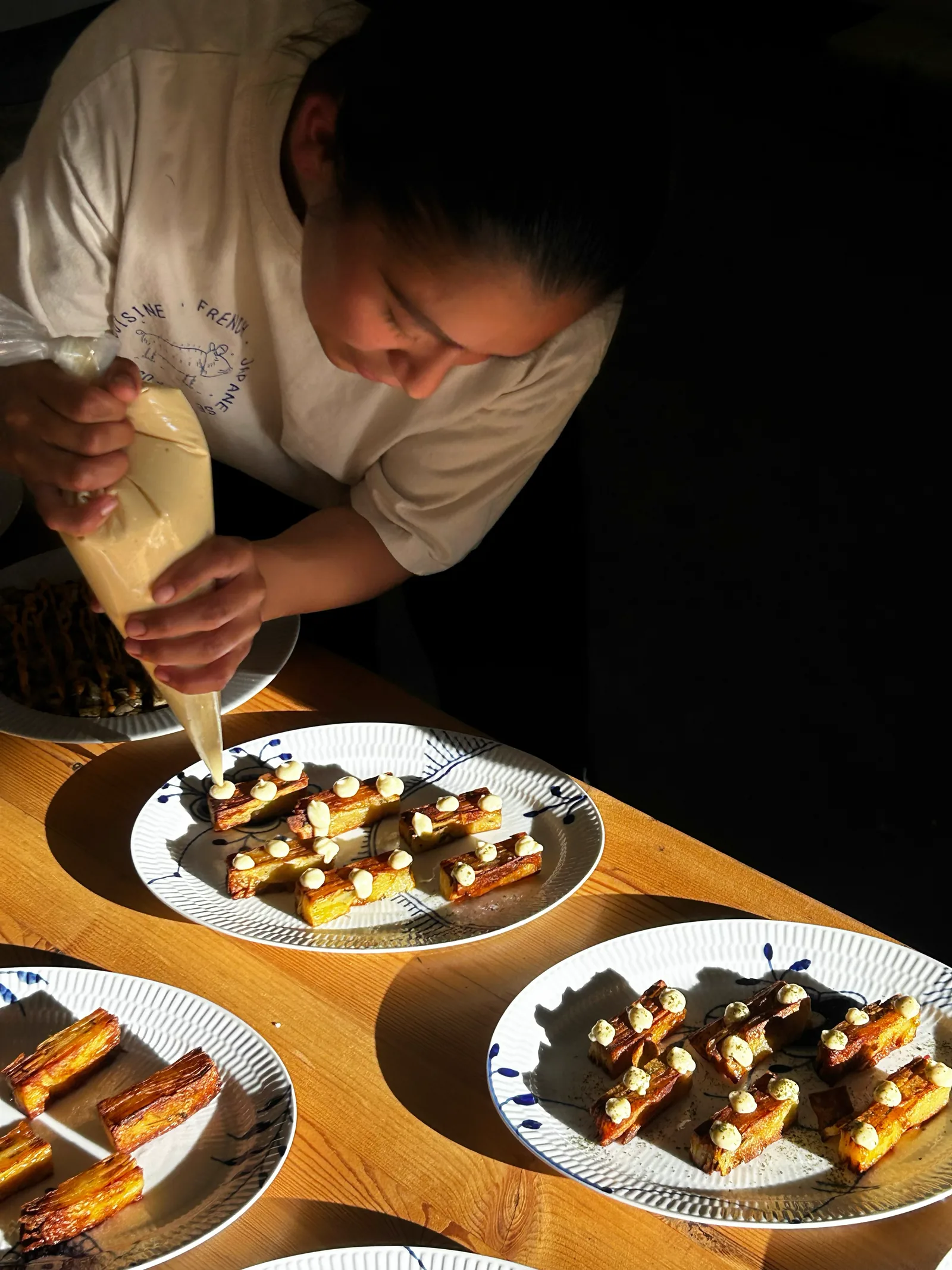 Amalie Krogsøe anretter kartoffelterrin med sauce — japansk-fransk private dining